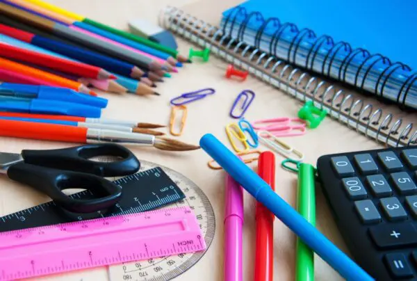 A table topped with lots of school supplies.