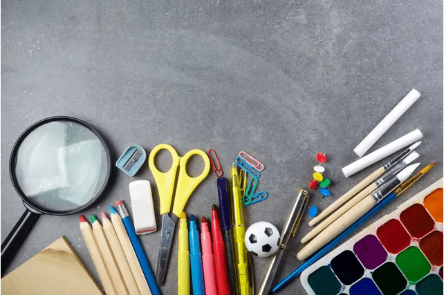 A table topped with school supplies and pencils.