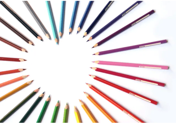 A circle of colored pencils arranged in the shape of a heart.